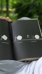 Diario abierto con ilustraciones de una figura empujando una piedra